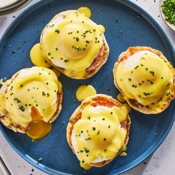 english muffins topped with ham, poached eggs and hollandaise on a plate