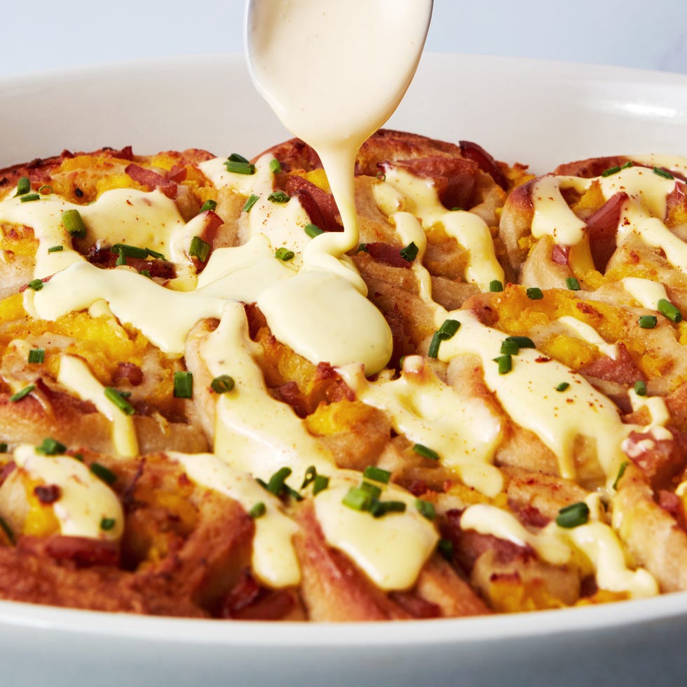 pinwheel style rolls baked in a casserole dish and topped with hollandaise