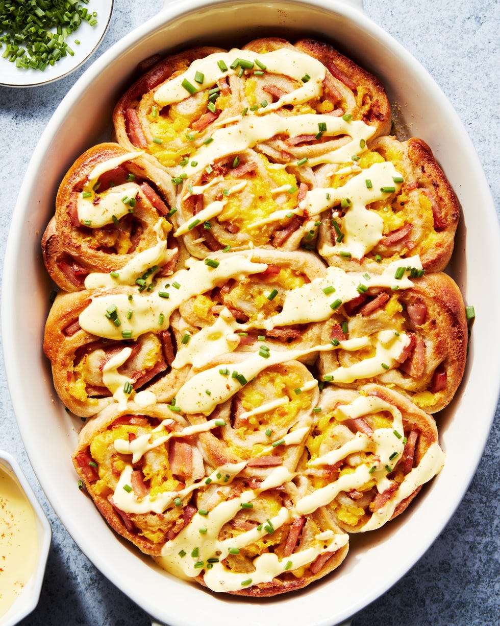 pinwheel style rolls baked in a casserole dish and topped with hollandaise