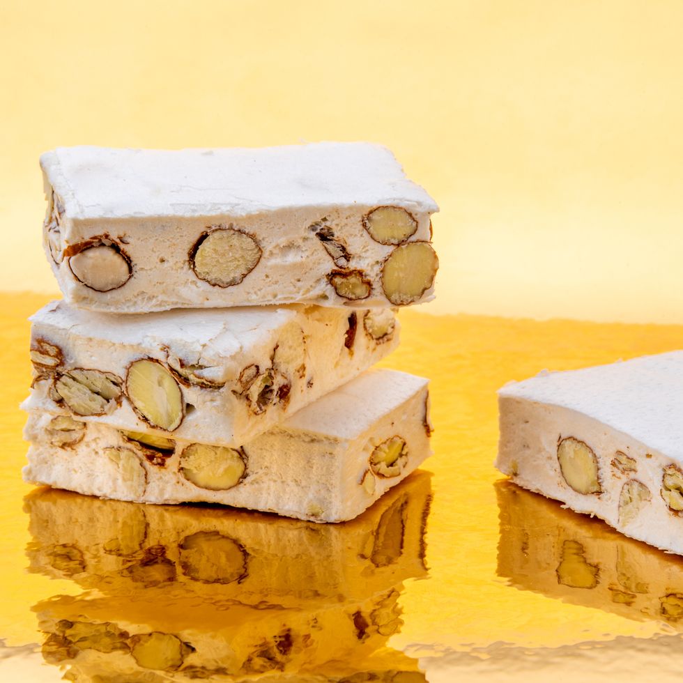 eid al fitr food nougat with almonds and hazelnuts on a golden background where it is reflected