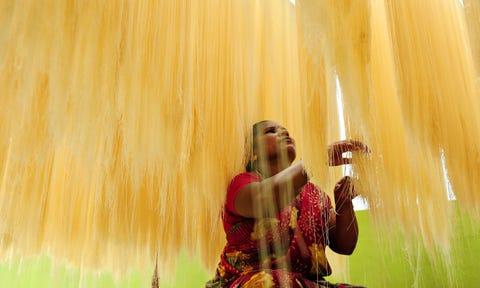 Een vrouw sorteert slierten seviyan dunne vermicelli die worden gebruikt om sheer khurma te maken een traditioneel zoet gerecht dat tijdens de ramadan in India wordt bereid