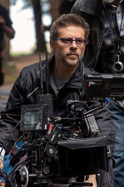 El mal crew members setting up and operating film equipment on a set