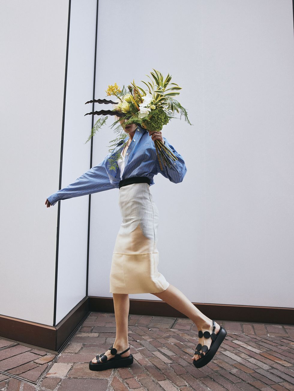 a person wearing a blue dress and holding flowers