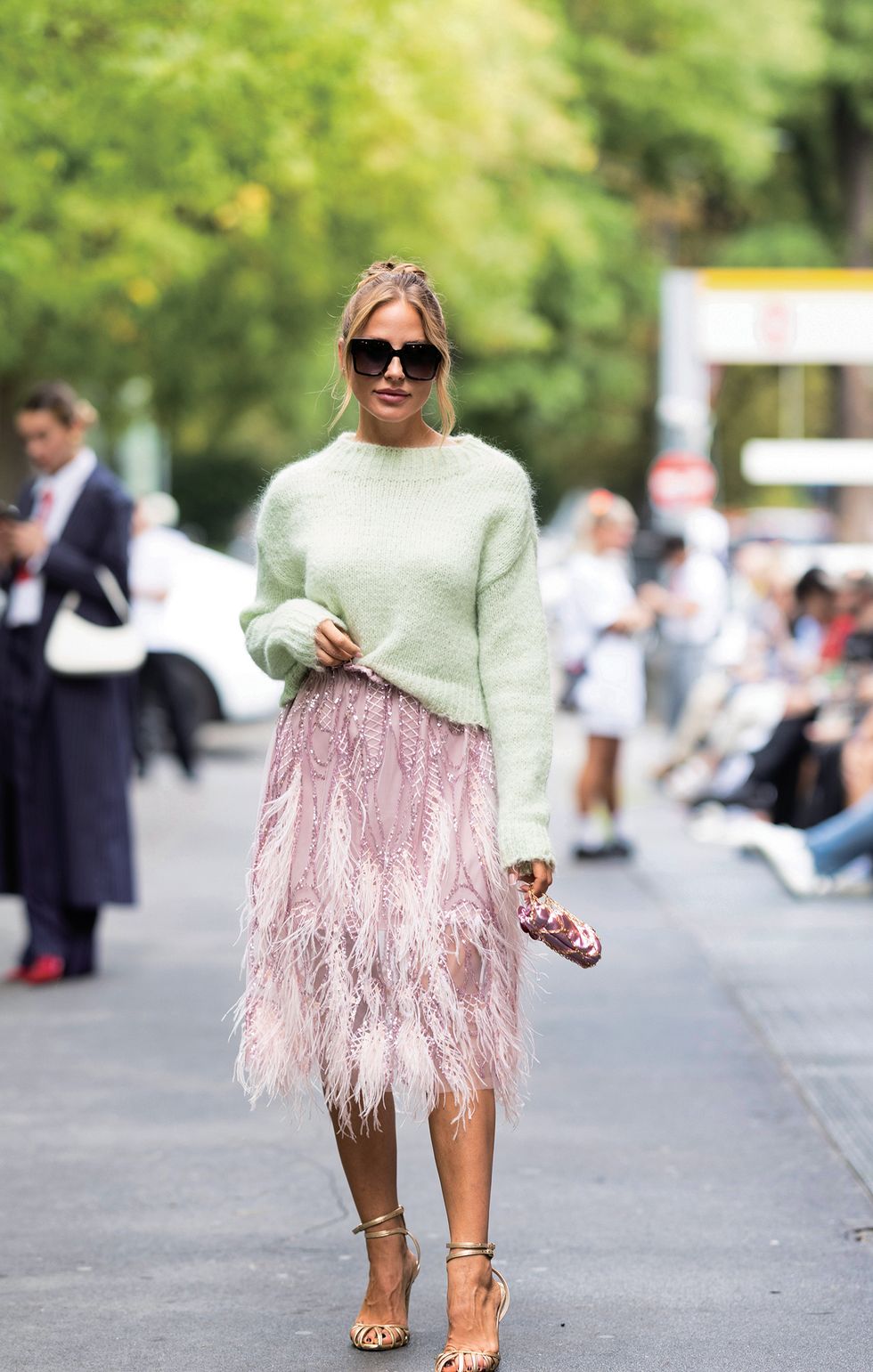 milan, italy september 20 ginta is seen wearing gold pumps, a mint green sweater, black sunglasses, a pink midi dress embellished with feathers and sequins and a pink shiny mini bag with gold hardware outside fendi show during the milan fashion week womenswear springsummer 2024 on september 20, 2023 in milan, italy photo by valentina frugiuelegetty images