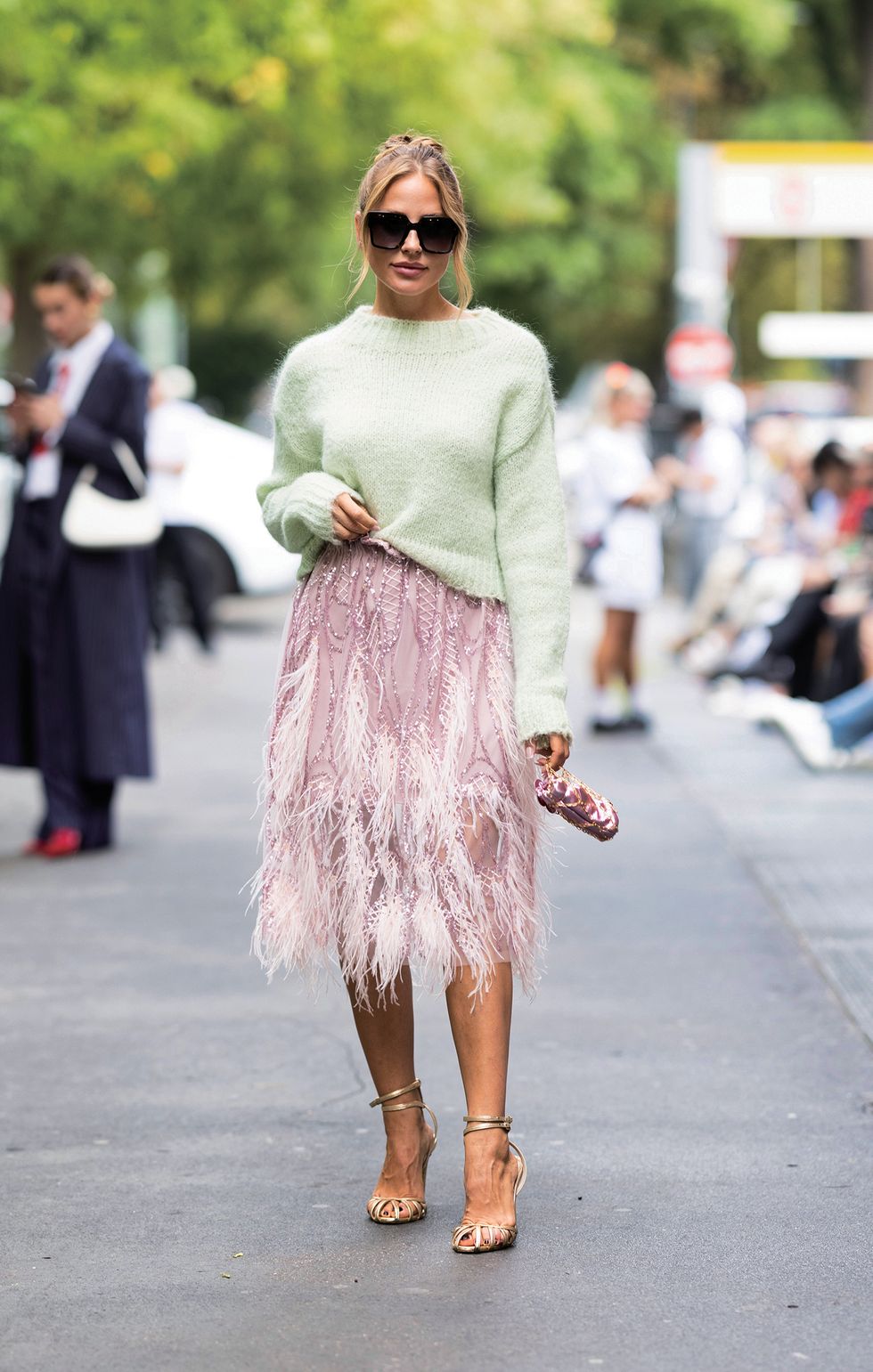 milan, italy september 20 ginta is seen wearing gold pumps, a mint green sweater, black sunglasses, a pink midi dress embellished with feathers and sequins and a pink shiny mini bag with gold hardware outside fendi show during the milan fashion week womenswear springsummer 2024 on september 20, 2023 in milan, italy photo by valentina frugiuelegetty images