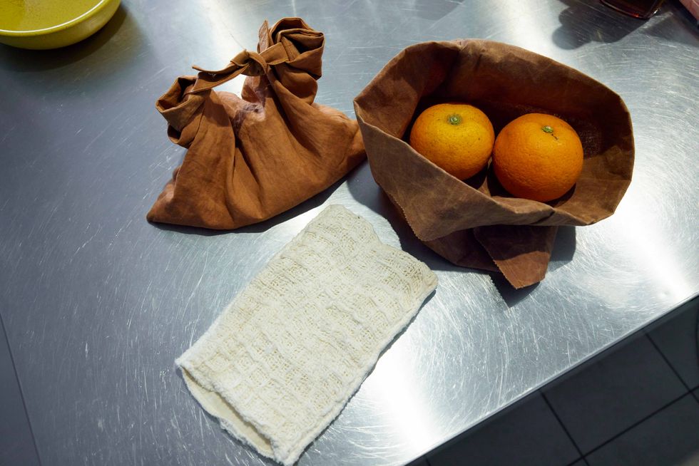a basket of oranges and a napkin on a table