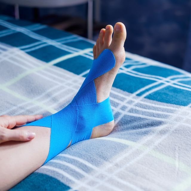 Elastic therapeutic blue tape applied to patient's left leg.