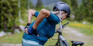 elderly cyclist having lower back pain from cycling