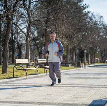 elderly man in sportswear jogs lightly for health in the park