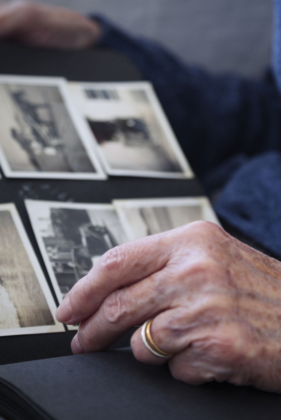 elderly woman looking at old fashioned photograph album