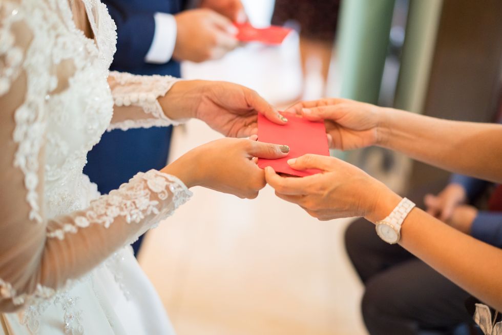 elders giving red packet to newlywed couple