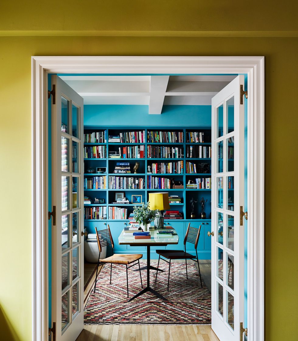 view into blue room with shelves and books from a chartreuse room through white french doors