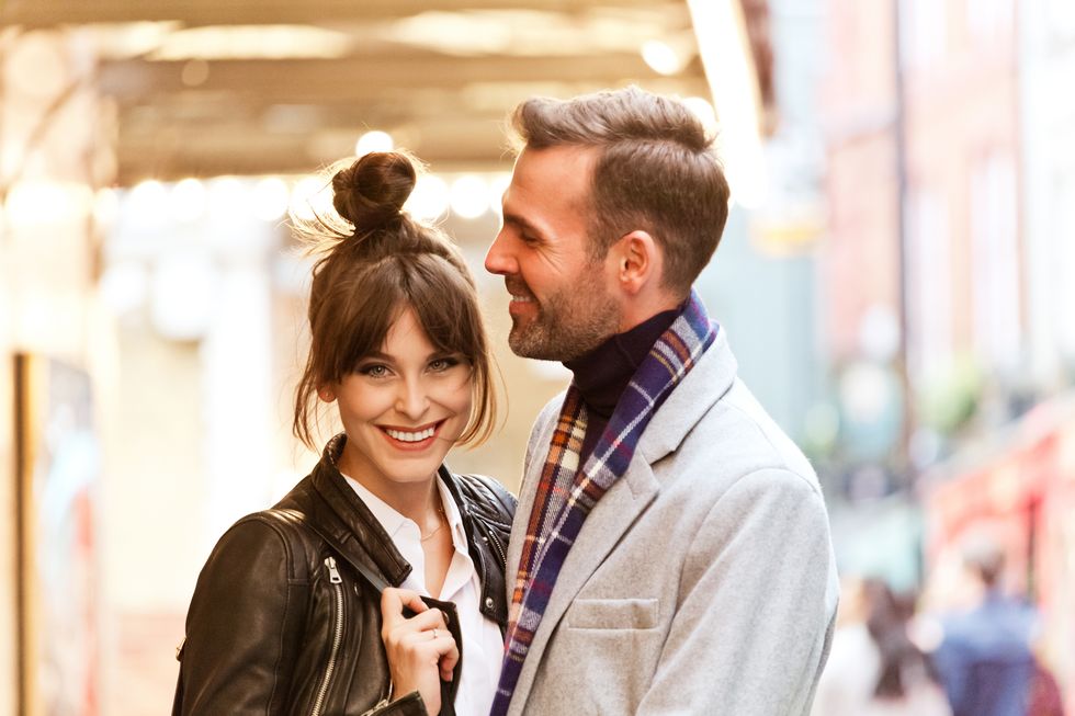 elegant couple in the city, beautiful woman smiling at camera