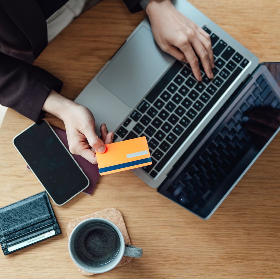 elevated view of female hands making credit card payment via laptop while doing online shopping