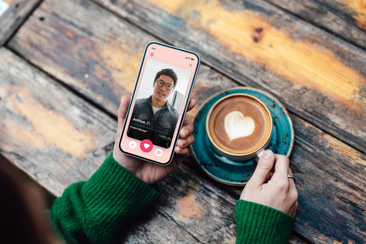 возвышенный взгляд на молодую женщину, ищущую любовь с помощью онлайн-приложения для знакомств на смартфоне, попивая кофе