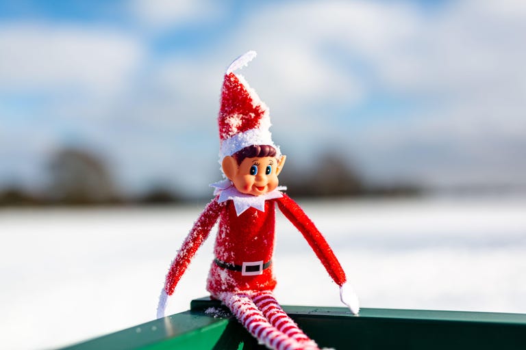 2gknxb0 a close up of a naughty christmas elf sitting outside in the snowy winter landscape enjoying the winter sunshine elf on the shelf, naughty, christmas