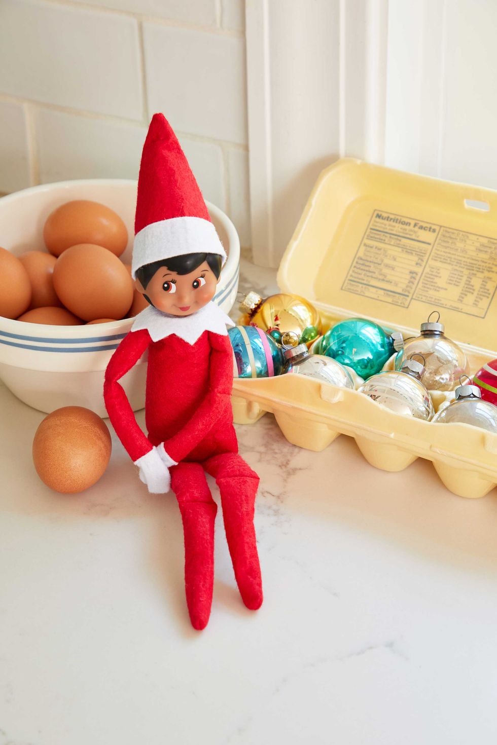 Elf on a shelf with eggs and ornaments