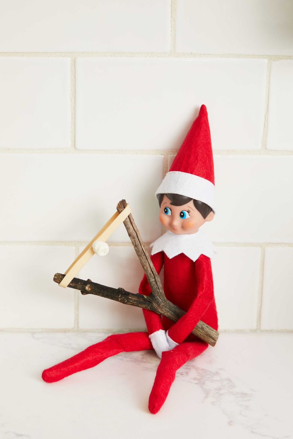 Elf holding a slingshot on the shelf