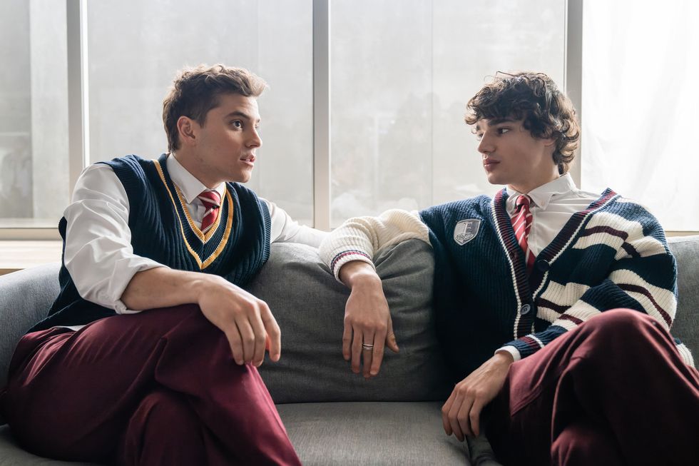 Ivan y Joel en élite, dos adolescentes sentados en un sofá con uniforme escolar mirándose