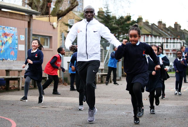 eliud kipchoge corre junto a varias niñas en londres