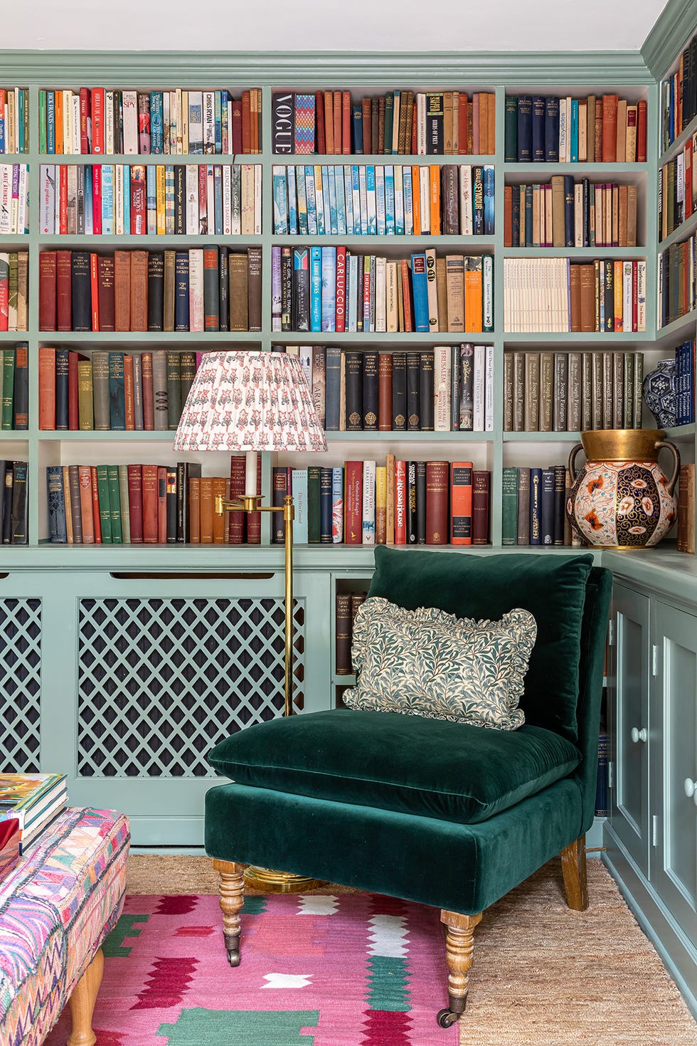 a green chair in front of a bookshelf