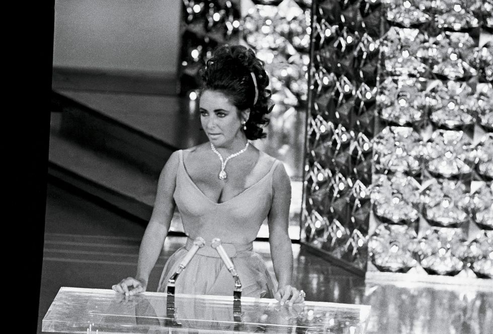 original caption wearing a beautifully displayed million dollar diamond and low cut gown, actress elizabeth taylor presents an "oscar" for the best movie in the 42nd annual academy awards at the music center the diamond was a gift from her husband, actor richard burton