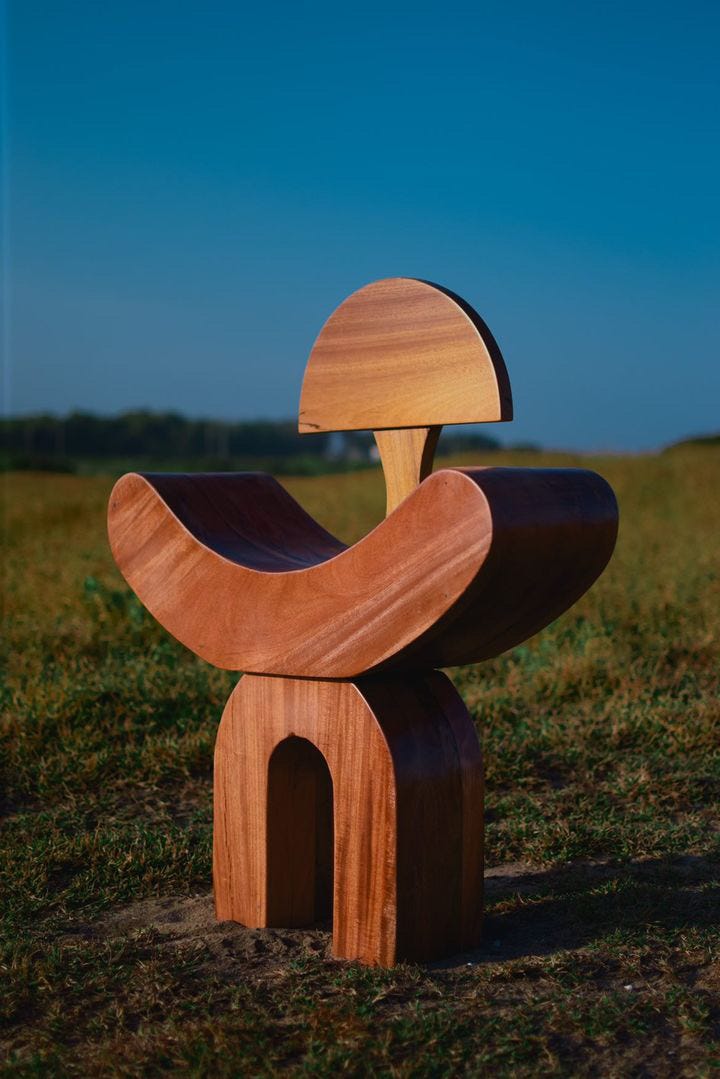 a sculptural wooden stool on grass