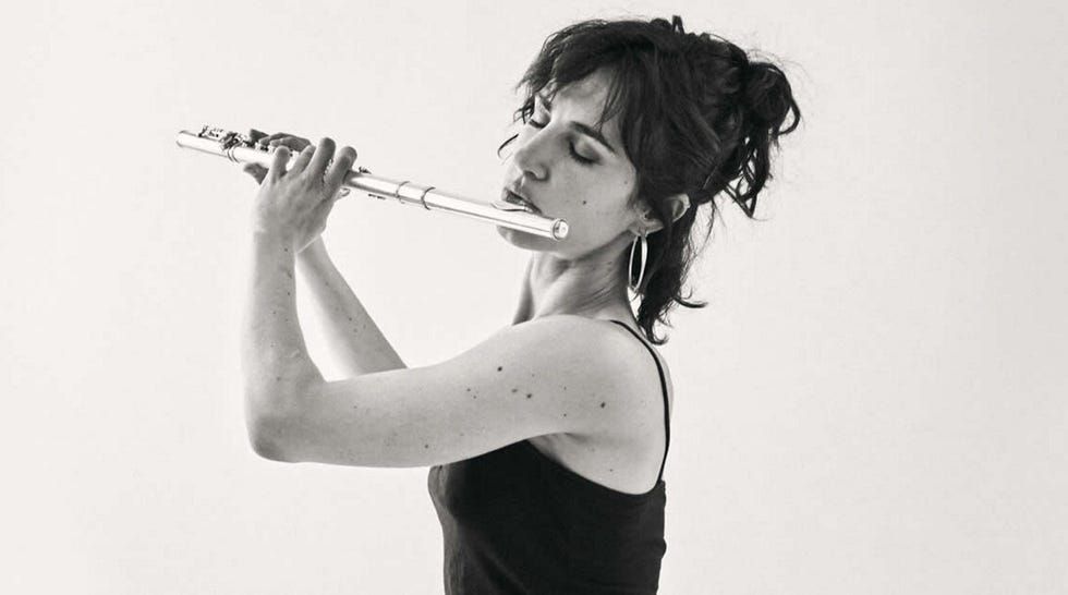 una mujer toca una flauta en una imagen en blanco y negro