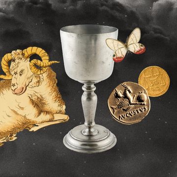 a cup with a butterfly, a ram, and coins