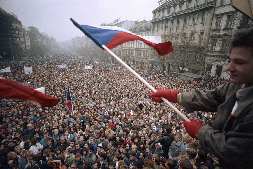 Man Waving Czech Flag Above Crowd