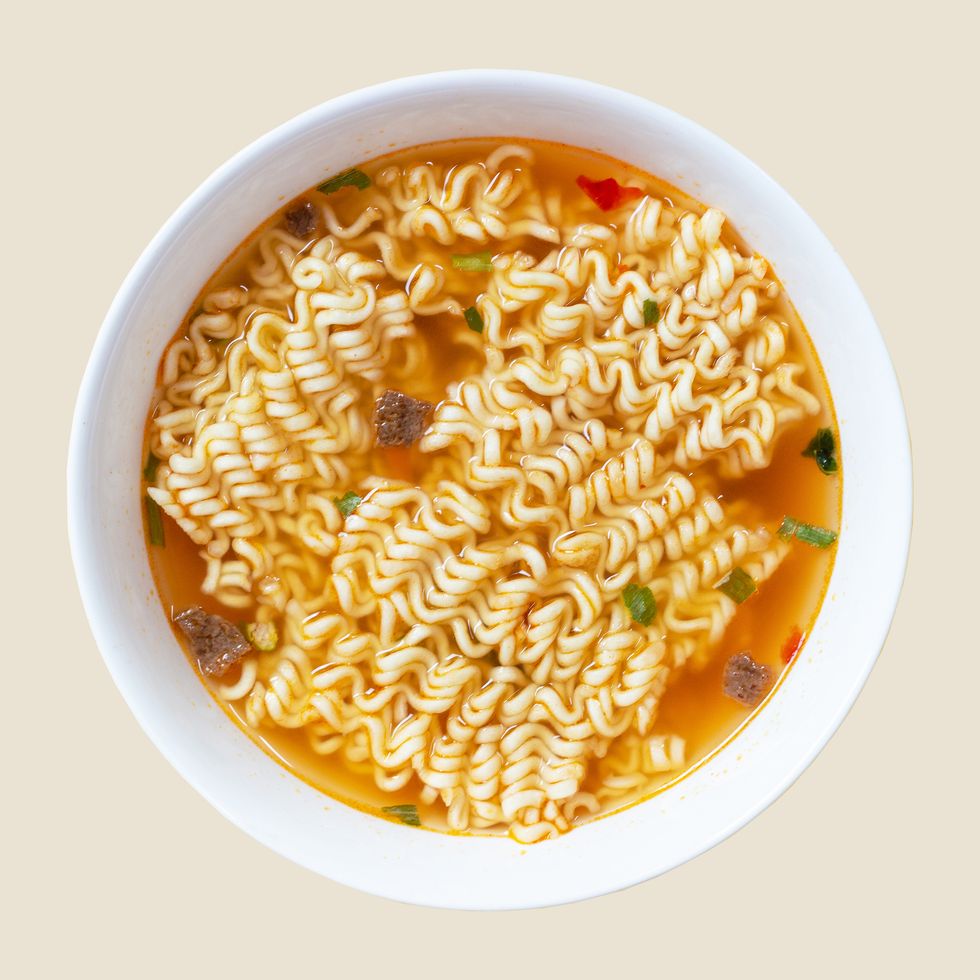 instant noodle soup in a white bowl on a yellow background top view