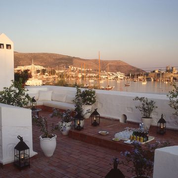 a rooftop with white buildings and a body of water in the background