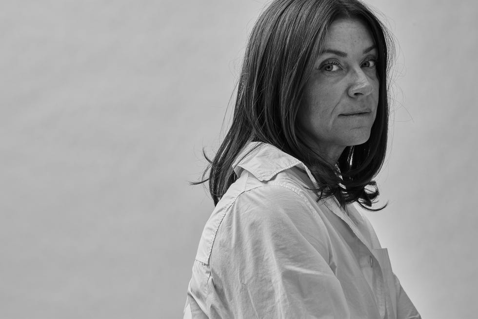 a person is depicted in profile, with long, straight hair gently cascading over their shoulder they are wearing a light colored button up shirt with a collar the background is softly neutral providing a minimalistic contrast to the subject the overall mood suggests a serene and contemplative atmosphere