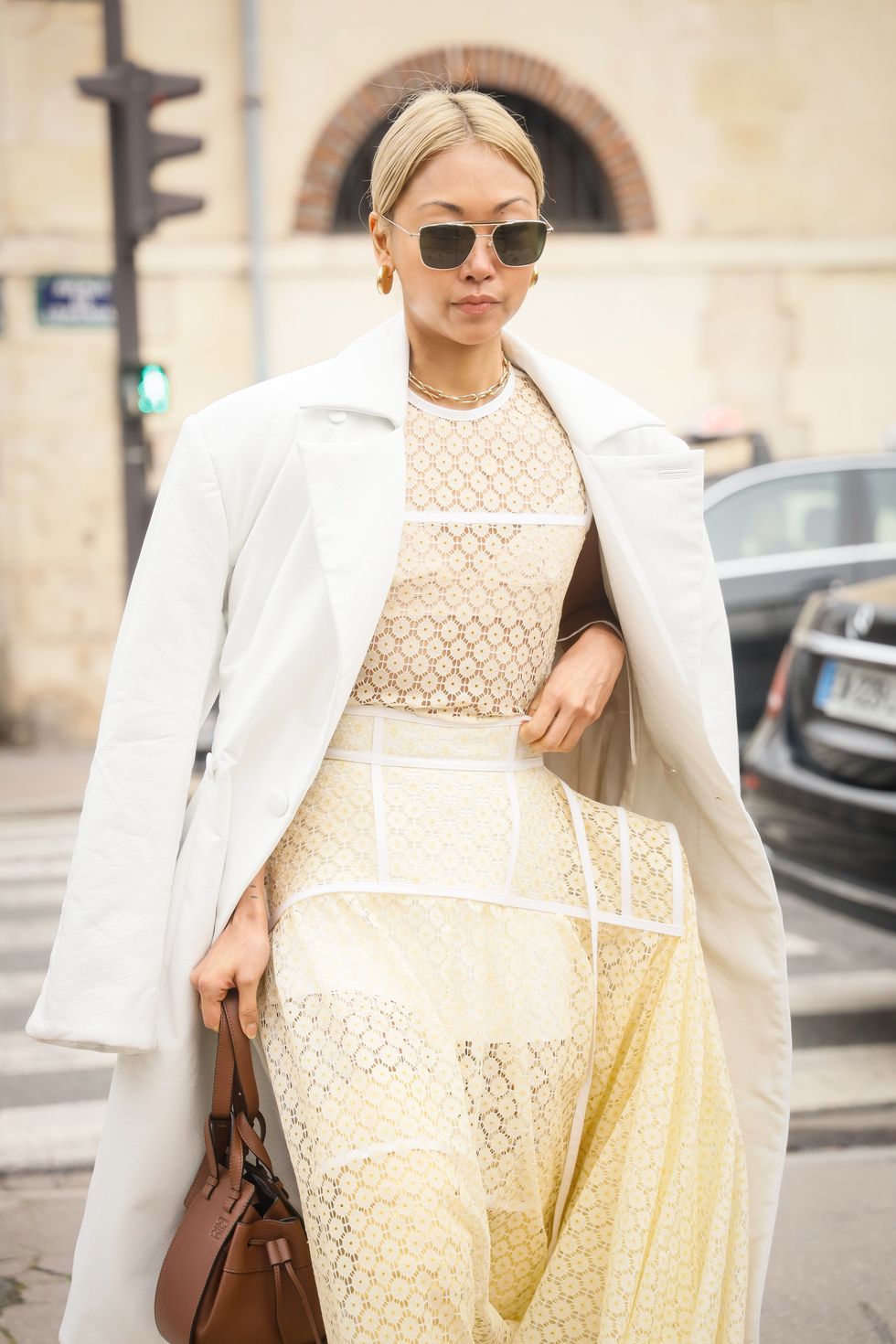 Inspiración street style con vestido de encaje amarillo suave y abrigo blanco