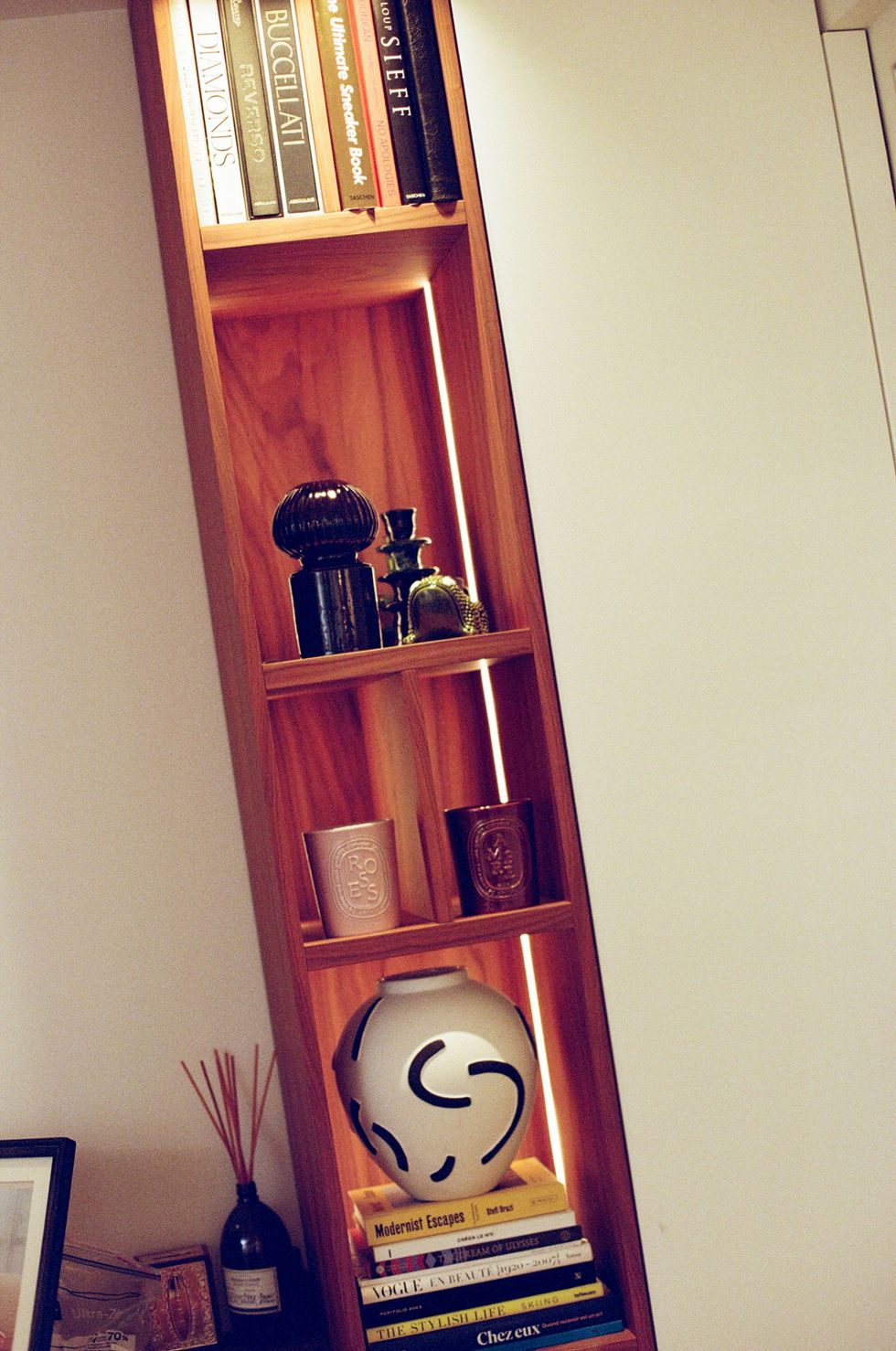 a book shelf with books and a bottle of wine