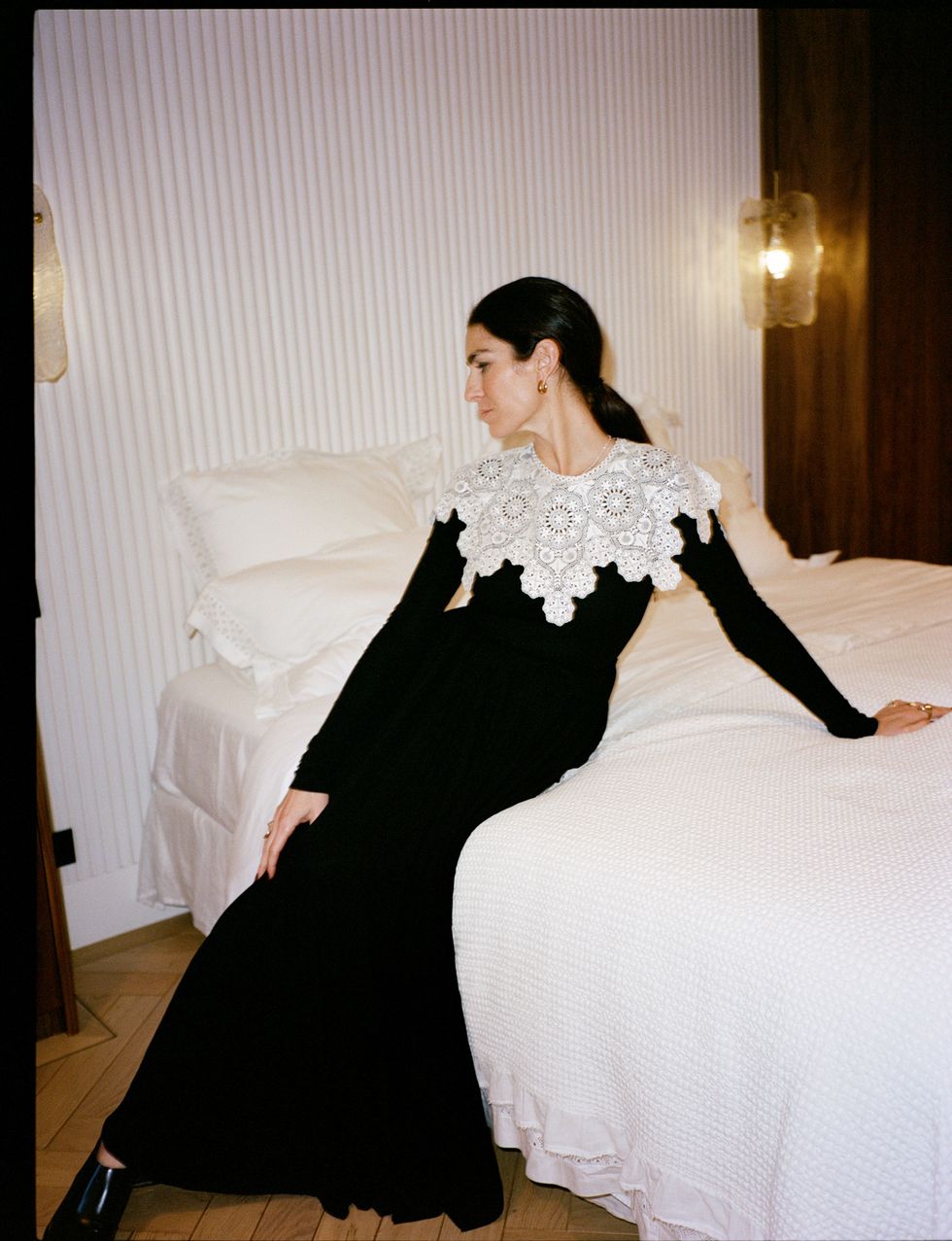 a person in a black dress lying on a bed