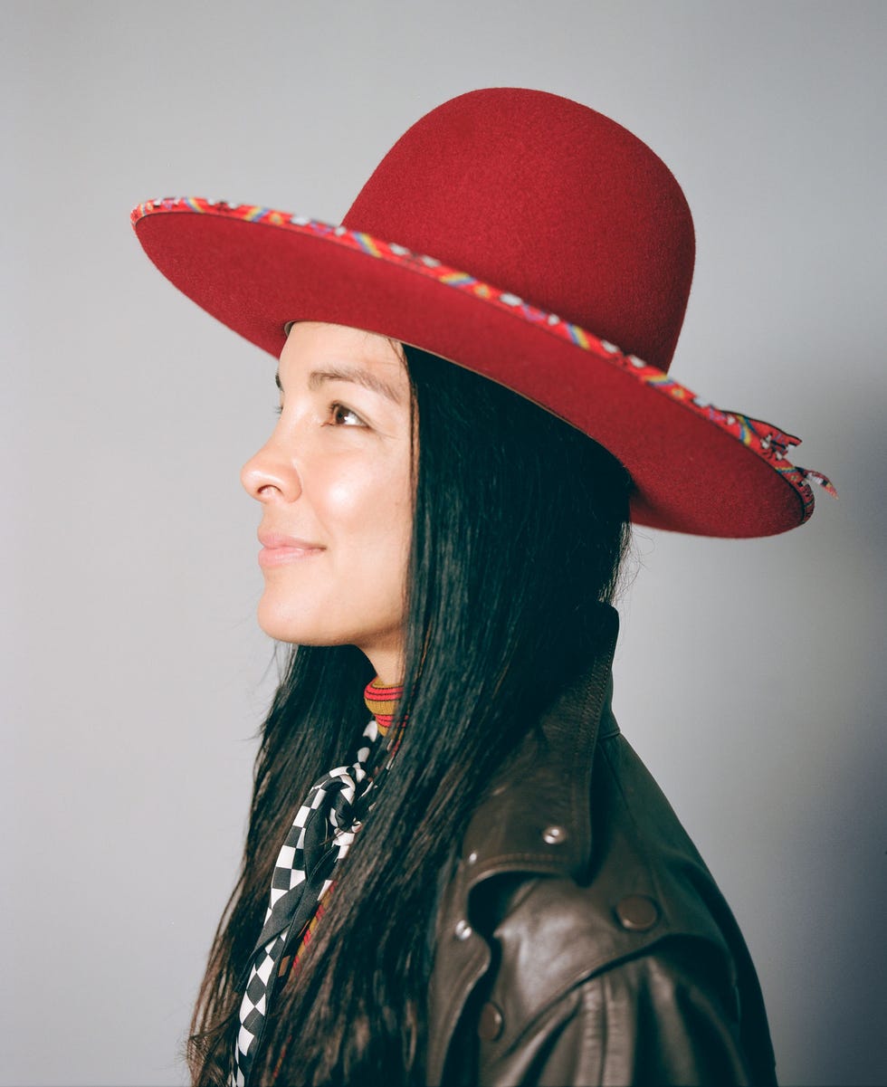 a person wearing a prominent red hat and a brown leather jacket