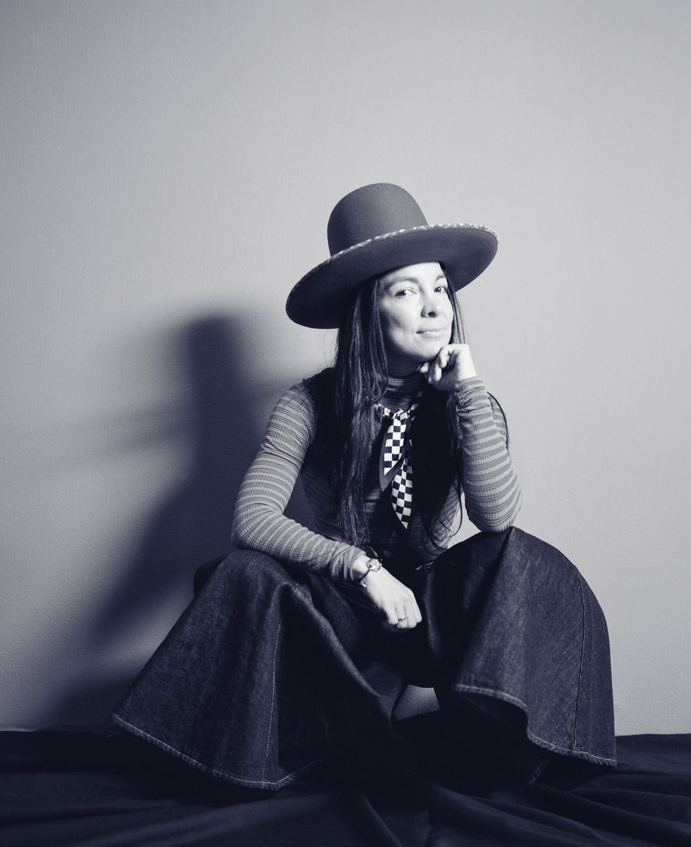 person seated with oversized hat and denim outfit