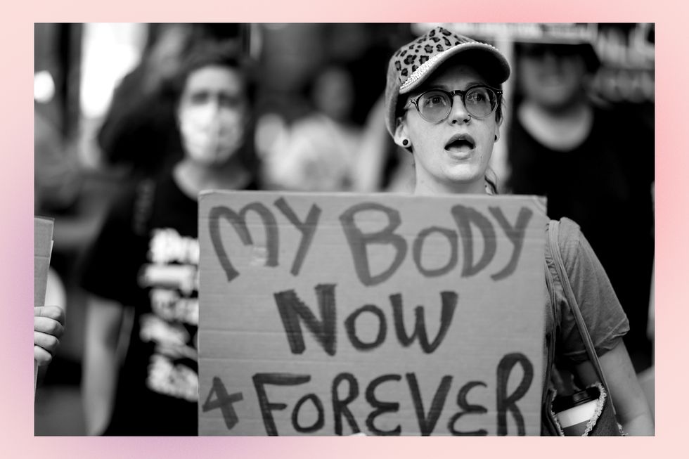 a protester holding a sign that reads my body now and forever