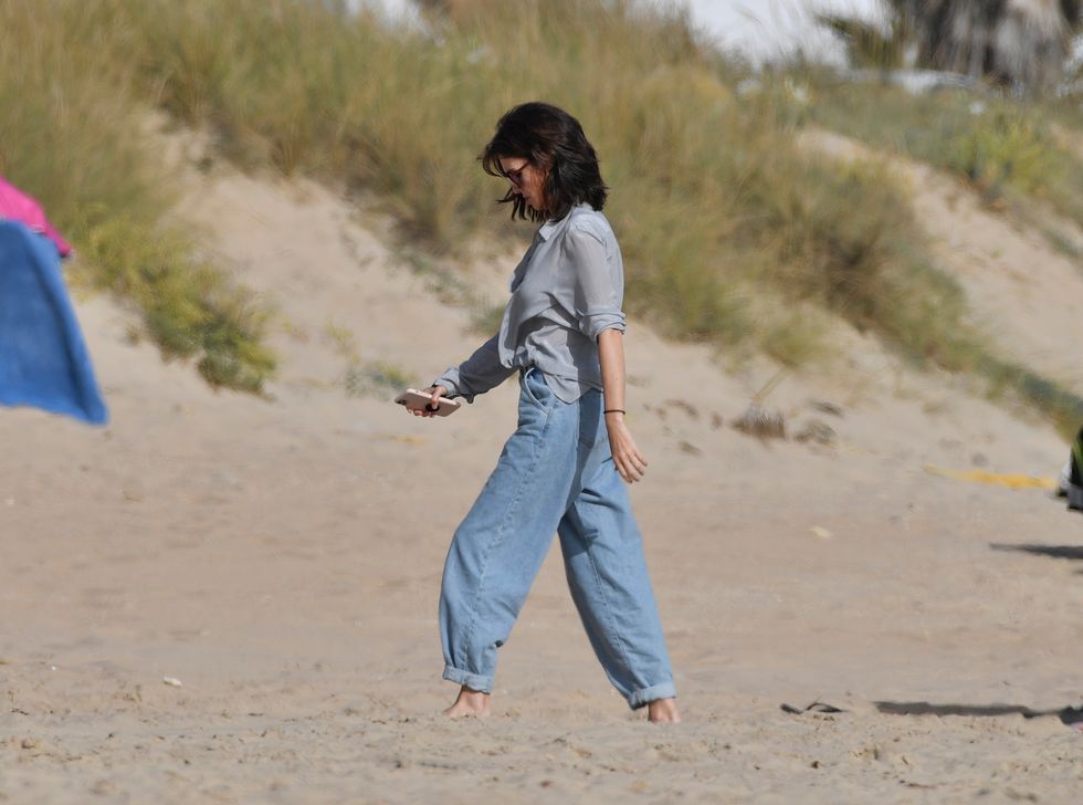paz vega con pantalones vaqueros anchos y camisa de rayas en un look playa