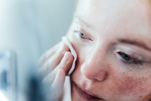 Woman cleaning her face.