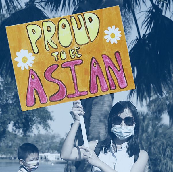 a woman shows a sign that reads proud to be asian during a rally against anti asian hate crimes