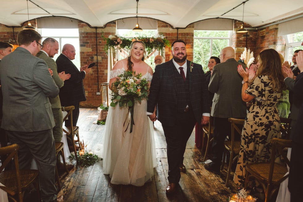 a wedding ceremony with a couple walking hand in hand