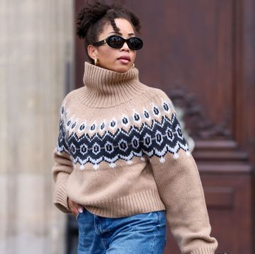 a woman wearing an oversized light brown fair isle sweater with jeans and sunglasses on teh street in pairs in a roundup of the best oversized sweaters 2024