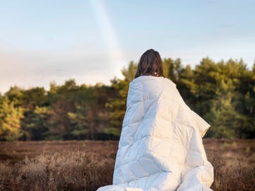 vrouw in groen landschap met dekbed