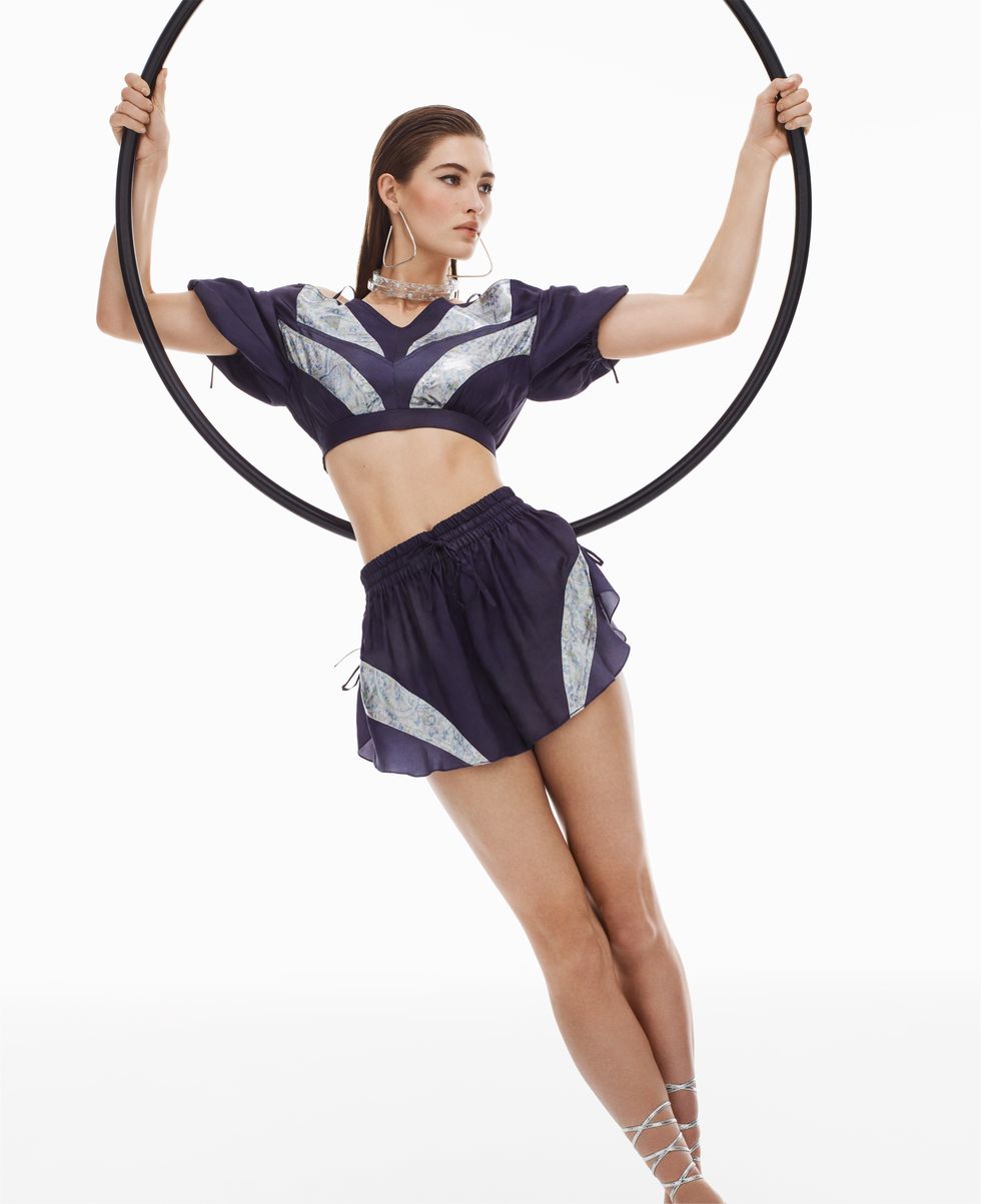 model grace elizabeth poses with a hoop in athletic shorts and top
