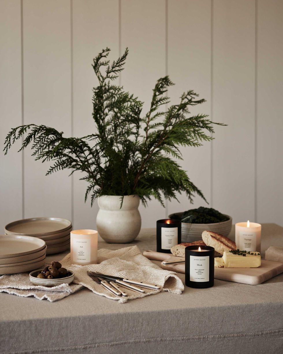 a tablescape featuring jenni kayne home candles, plates, and cutlery