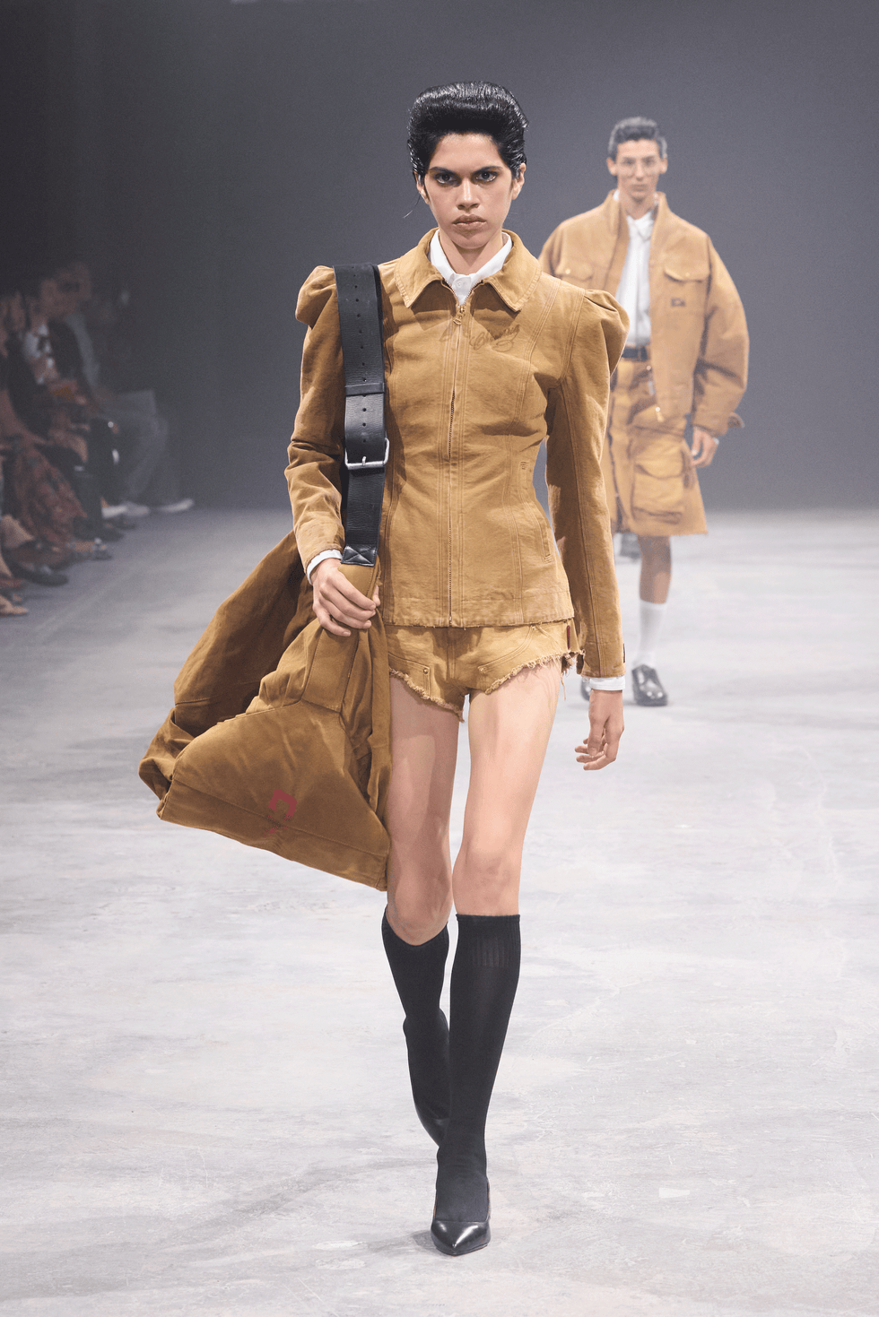 model showcasing a brown outfit on a runway