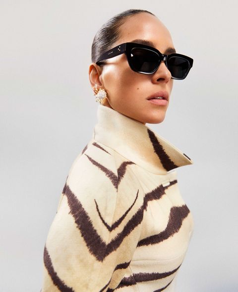 adria arjona models sunglasses, diamond earrings, and an animal print coat