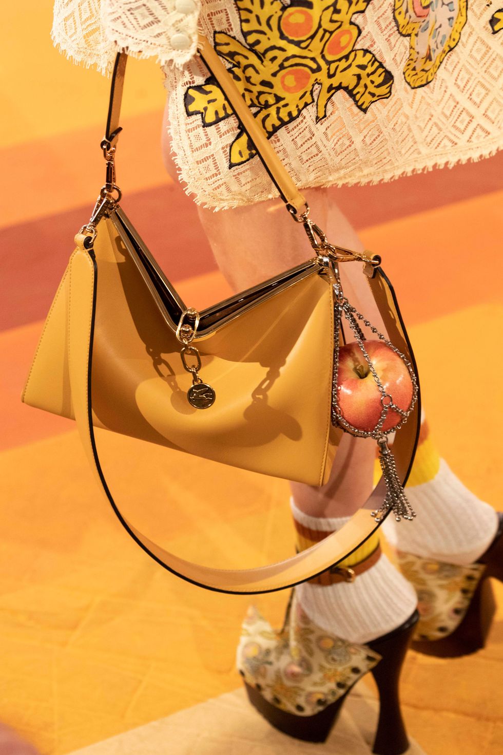 a yellow handbag with an apple attached